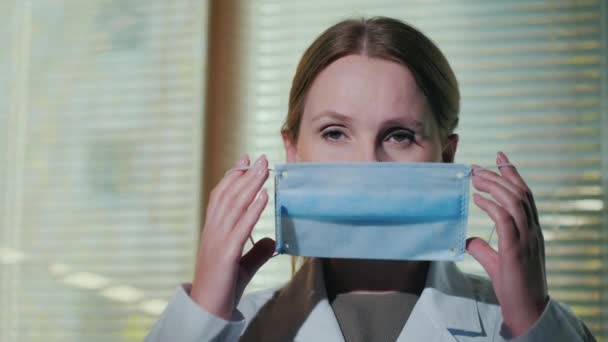 Female doctor shows how to wear a medical mask - Felvétel, videó