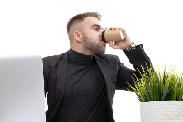 The guy drinking coffee in the workplace - Foto, Imagen