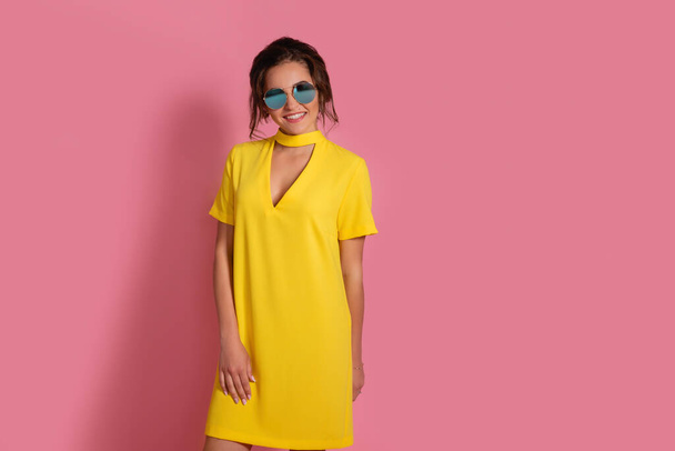 Beautiful girl in colorful clothes wearing sunglasses - 写真・画像