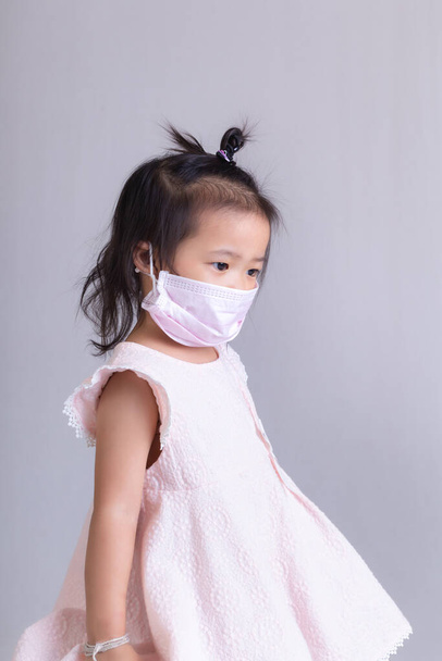 Mała dziewczynka w masce dla ochrony siebie.Covid-19 Concept. - Zdjęcie, obraz
