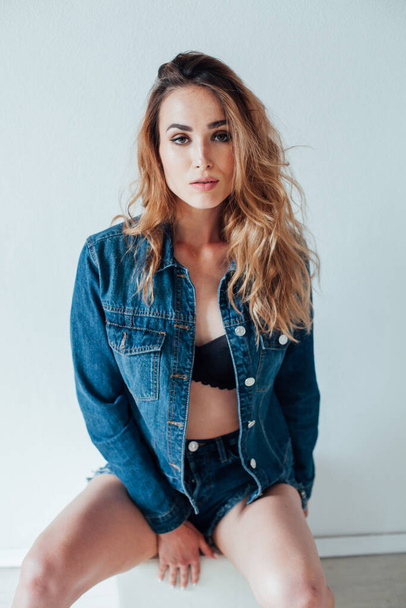 Portrait of a beautiful fashionable woman in black lingerie and denim shorts - Photo, Image