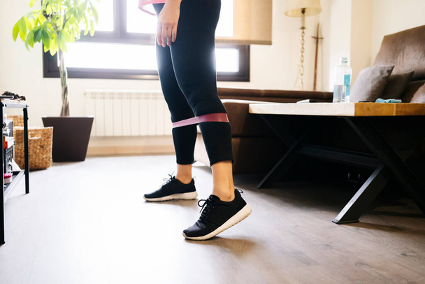 bella donna atleta caucasica bionda che fa esercizi con elastico in soggiorno a casa
 - Foto, immagini