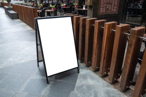 Tyhjä valkoinen ulkona mainonta stand / sandwich board mockup malli. Tyhjennä kadun kyltti sijoitettu ulkona ruokailutila ravintola. Taustan rakenne standee on the et
. - Valokuva, kuva