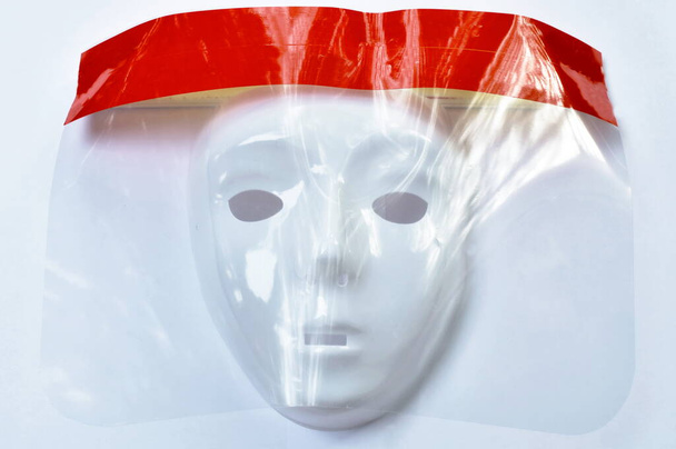  保護コロナウイルスやCOVID -19のためのプラスチック製の顔シールドを身に着けているマスクは、白い背景に - 写真・画像