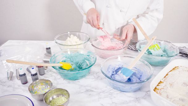 Mezclar colorante de alimentos en glaseado de crema de mantequilla italiana. - Foto, Imagen