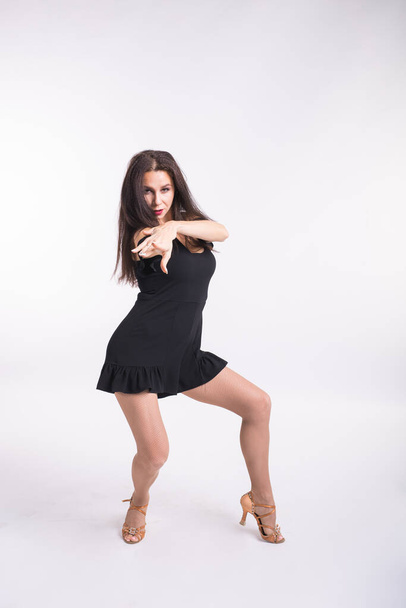 Latina dance, strip dance, contemporary and bachata lady concept - Γυναίκα που χορεύει αυτοσχεδιασμό και κινεί τα μακριά μαλλιά της σε λευκό φόντο. - Φωτογραφία, εικόνα