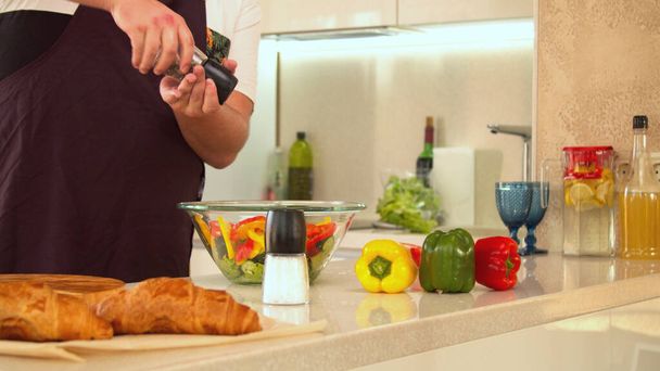 Férfi fűszerezés friss zöld saláta sóval - Fotó, kép