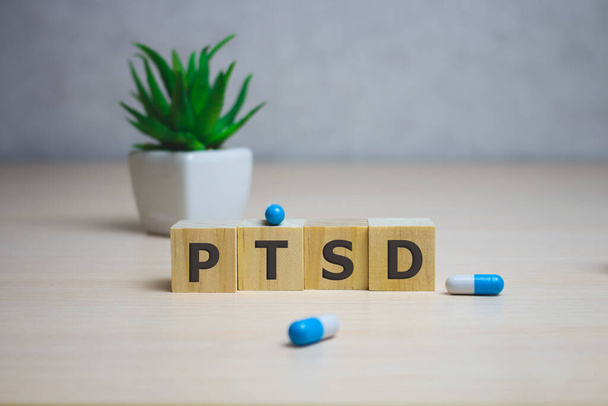 The word PTSD written in wooden cubes on white background. - Photo, image