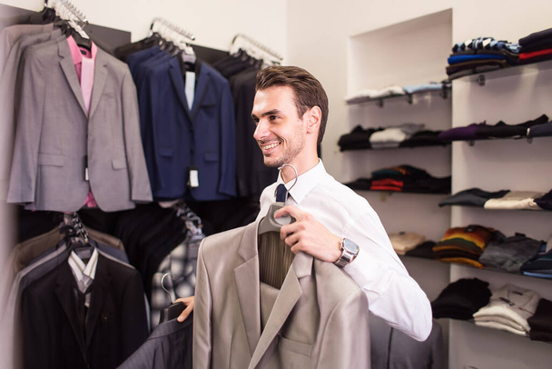 The man buyer chooses jacket the boutique - Фото, зображення