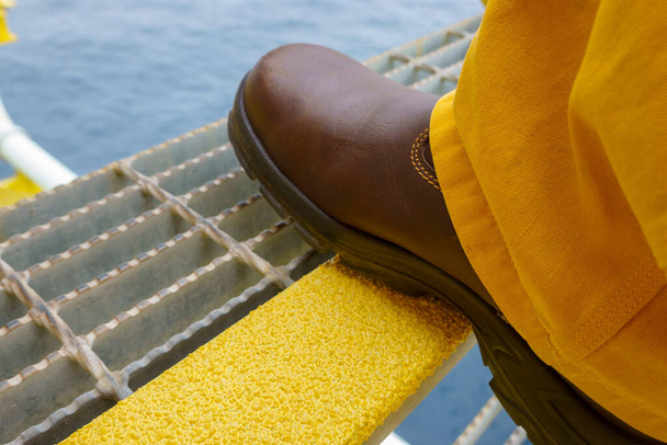 Крупним планом Промисловість сталеві сходи з жовтою протиковзкою пластиною з кроком безпеки взуття на протекторі
. - Фото, зображення