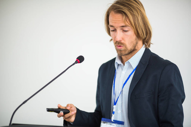 Schöner junger Mann hält eine Rede auf einer Konferenz - Foto, Bild