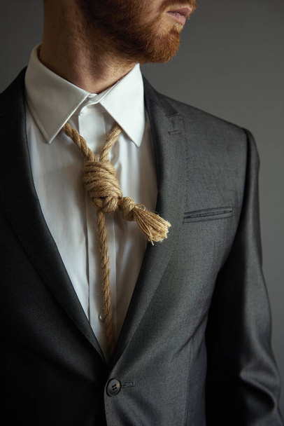 Concept image of business in trouble. Man in suit with Lynch loop instead of tie over neck. - Fotografie, Obrázek