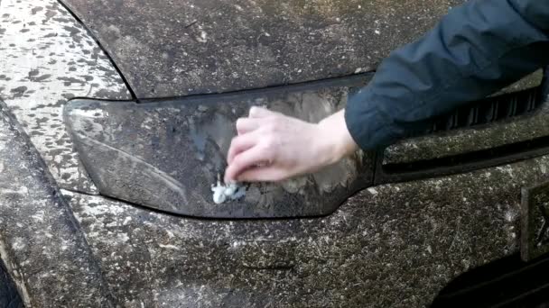 Um homem lava e esfrega um farol muito sujo de um SUV sujo. Mão para cima
 - Filmagem, Vídeo