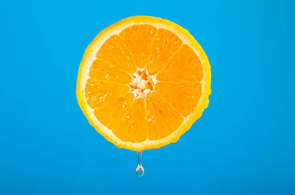 Eine halbe Orange. Zitrusfrüchte schneiden. Frisch gepresster Orangensaft. Obst auf niedrigem Untergrund. Perfekt für die Ernährung. Vegetarisches Essen. Wassertropfen auf der Haut. Nur Vitamine. - Foto, Bild