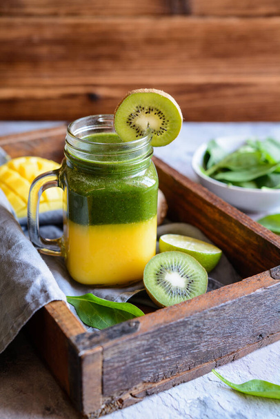 Στρώσεων φρέσκο μάνγκο, σπανάκι, ακτινίδιο και smoothie lime - Φωτογραφία, εικόνα