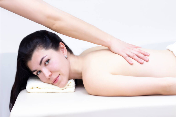 massage in a spa salon for a girl. Wellness massage concept. light background - Foto, afbeelding