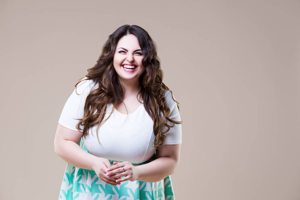 Laughing happy plus size model in casual clothes, fat woman on beige background, body positive concept - Foto, Imagem