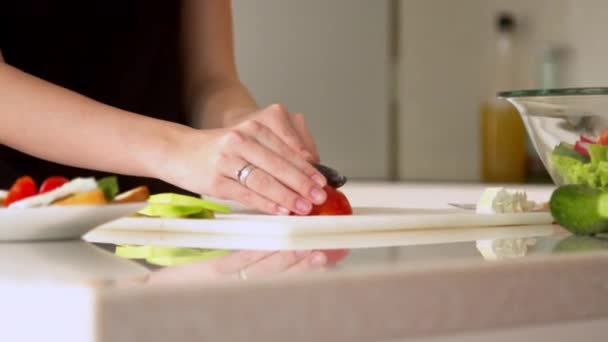Woman cutting tomatoes in kitchen  - Materiał filmowy, wideo