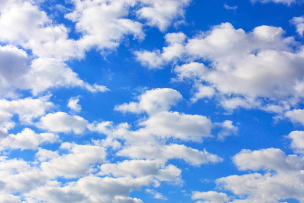 Blauwe lucht met witte pluizige wolken hoog boven je hoofd. - Foto, afbeelding