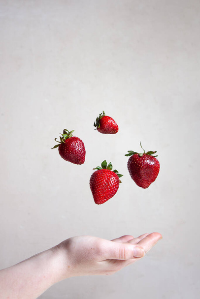 red strawberries floating in the air on a gray background - Photo, Image