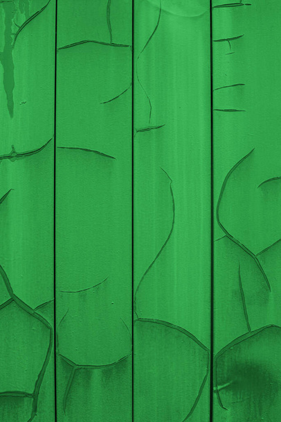 Vertical metal siding painted in bright green with cracks and erosion, old wall sheathing surface, textured effect. Background wallpaper backdrop texture for design. Green painted plates - Zdjęcie, obraz