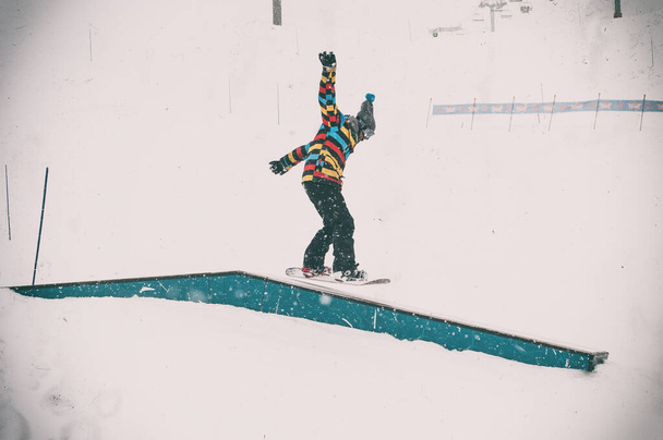 Фрірайдер сноубордист робить основні сноубордистські рейки трюк у фрістайлі сноупарк. Зимовий гірський сезон
  - Фото, зображення