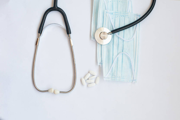 sztetoszkóp és kék orvosi maszk fehér alapon - Fotó, kép