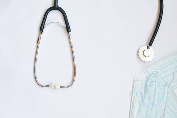 sztetoszkóp és kék orvosi maszk fehér alapon - Fotó, kép