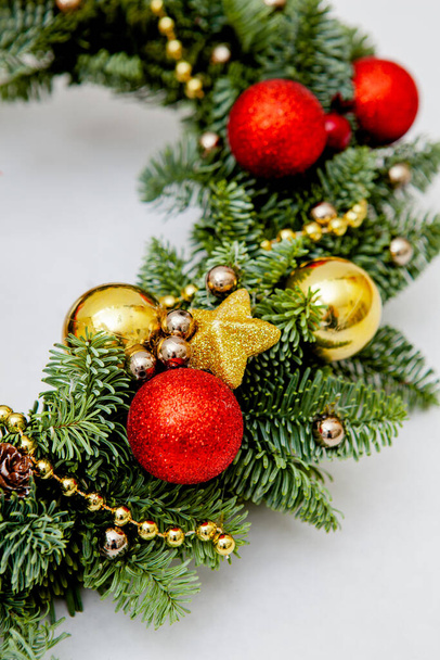 Téli koszorú fenyő tűk dekoráció piros és arany karácsonyi játékok - Fotó, kép