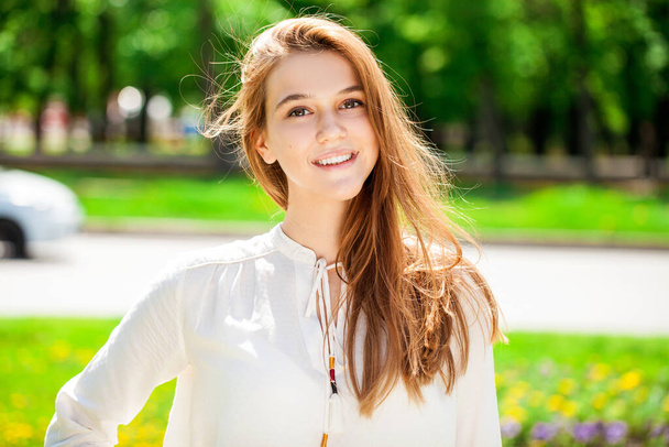 Close up portrait of a young beautiful brunette  girl in summer park - Foto, imagen