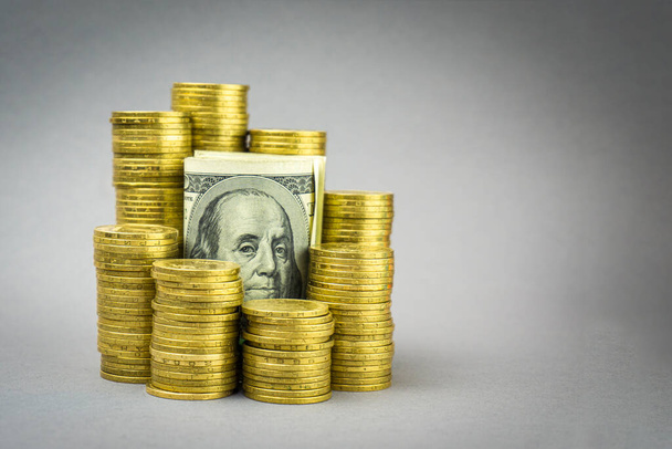 billete de cien dólares con monedas de oro sobre un fondo gris. concepto financiero
 - Foto, Imagen