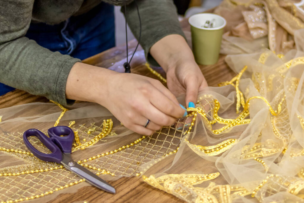Zarif bir gece elbisesi yapma süreci. Kız tasarımcı materyalin üzerine yapay elmaslar işliyor.. - Fotoğraf, Görsel
