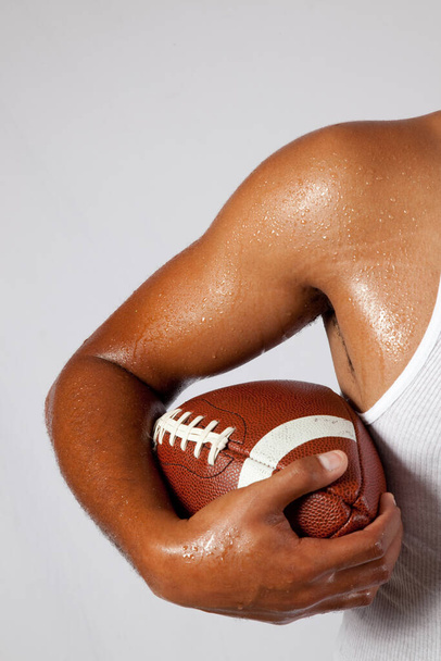Komea musta mies amerikkalaisen jalkapallon kanssa
 - Valokuva, kuva
