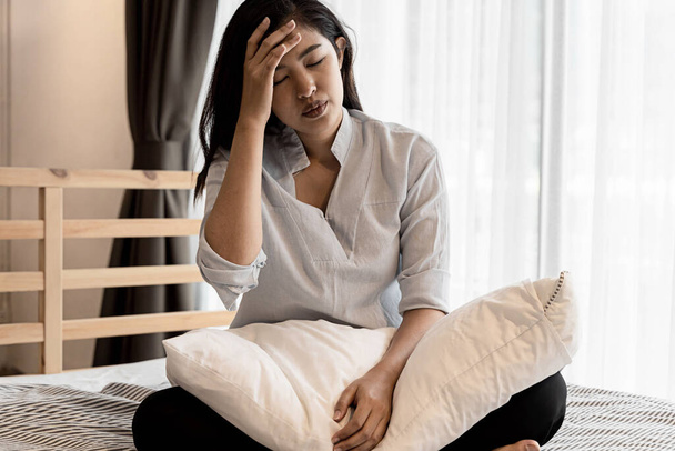Portret dwudziestki młodej Azjatki cierpiącej w nocy na ból i chorobę medyczną w sypialni. Gorączka, wysoka temperatura, zimno, migrena, zmęczenie, objawy. - Zdjęcie, obraz