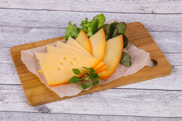 Fette di formaggio giallo svizzero affettato servito foglie di insalata - Foto, immagini