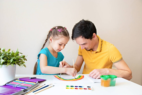 Father and daughter draw a rainbow together. Father and child spend a fun time while drawing. Happy family. Spending more time with loved ones - Foto, Imagen
