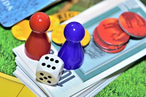 Kostky, modrá, červené figurky, žetony a herní peníze na desce. - Fotografie, Obrázek