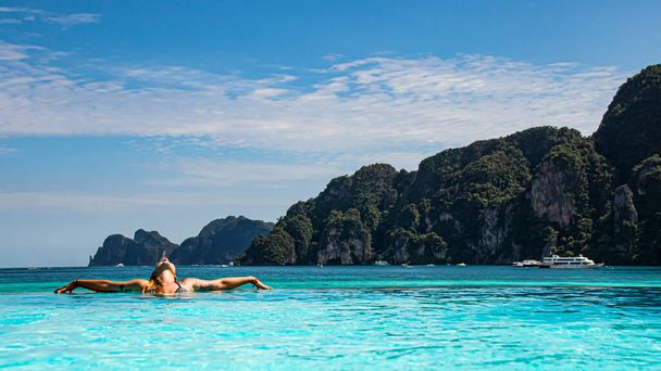 hezká žena relaxace v nekonečném bazénu, při pohledu na moře a těší dovolenou. - Fotografie, Obrázek