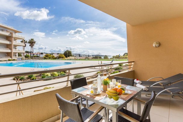 Zdrowe śniadanie z owocami i sokiem w luksusowym kurorcie z widokiem na basen i piękny ogród. Wakacje w Algarve. - Zdjęcie, obraz