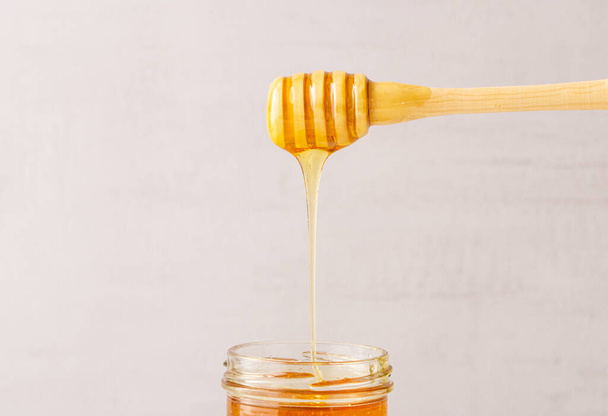 Honey jar, pot, wooden spoon. Health. immunity. Isolated. Copy space.  - Fotografie, Obrázek
