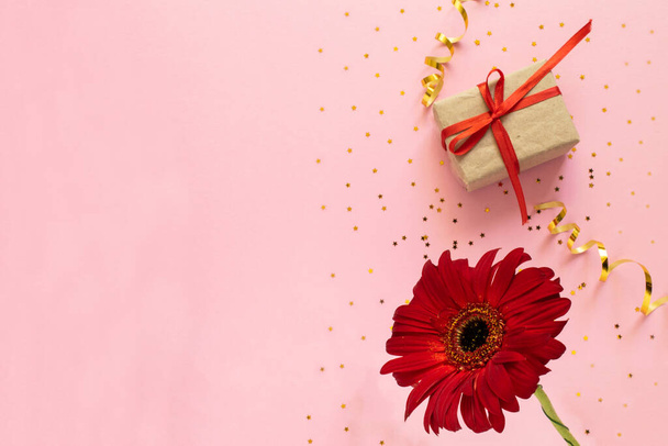 Beautiful red gerbera flower and gift box on pink background. Happy Mother's Day, Women's Day, Valentine's Day or Birthday greeting card. celebration greeting concept, flat lay and copy space - Foto, Imagen