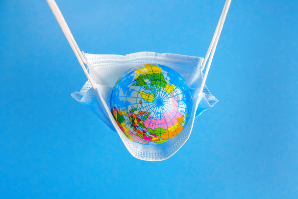 Earth globe in medicine mask to fight against Corona virus - Foto, Bild