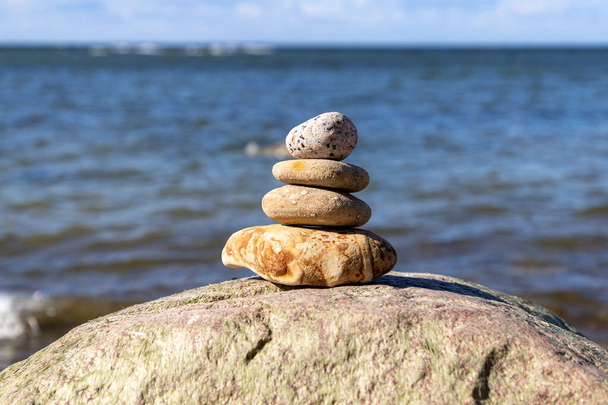 Понятие гармонии и равновесия. Скала на фоне летнего пляжа
. - Фото, изображение