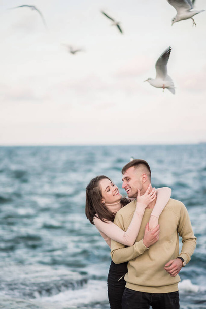 Las gaviotas vuelan sobre hermosa pareja joven feliz
 - Foto, Imagen