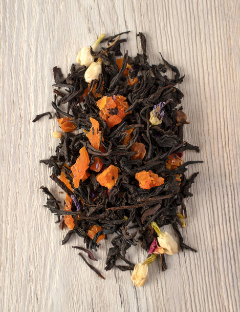 Черный чай с кусочками сухофруктов, ягод и цветов
. - Фото, изображение