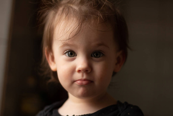 Retrato de cerca de un pequeño bebé blanco lindo con una cara sucia en luz suave y fondo borroso
 - Foto, Imagen