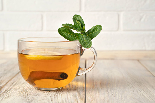 Transparent Cup with fragrant black tea, mint and cinnamon. - Photo, Image