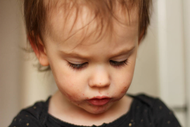 Крупный план портрета маленького милого белого малыша с грязным лицом на мягком светлом и размытом фоне
 - Фото, изображение