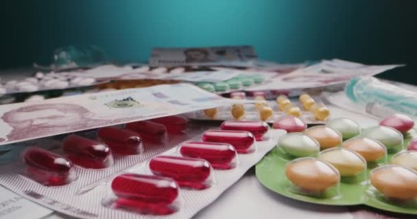 Bankjegyek között fekvő csomagolt gyógyszerek - Felvétel, videó