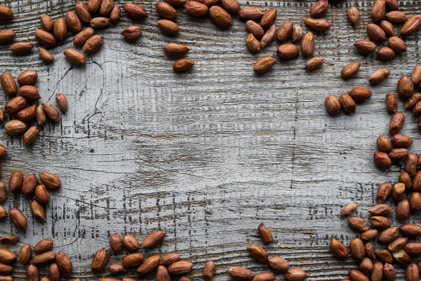 Peanut nuts scattered on the wooden vintage table. Peanuts nut is a healthy vegetarian protein nutritious food. - 写真・画像